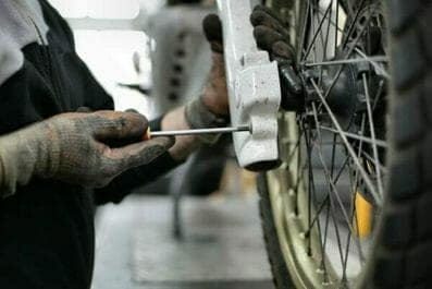 Someone repairing a dirt bike that uses bulk wire or safety Wire